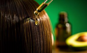 Illustration of avocado oil being applied to hair to boost shine in a single application.